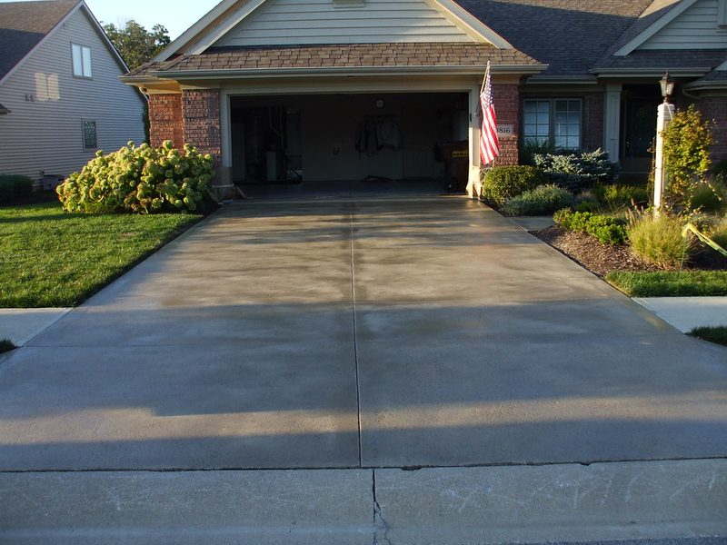 Broom finish concrete driveway at a brick suburban home