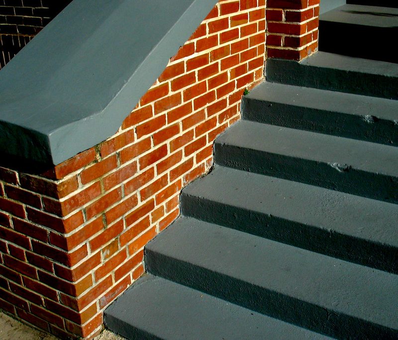 Concrete front steps with brick cheek walls at a residential entry